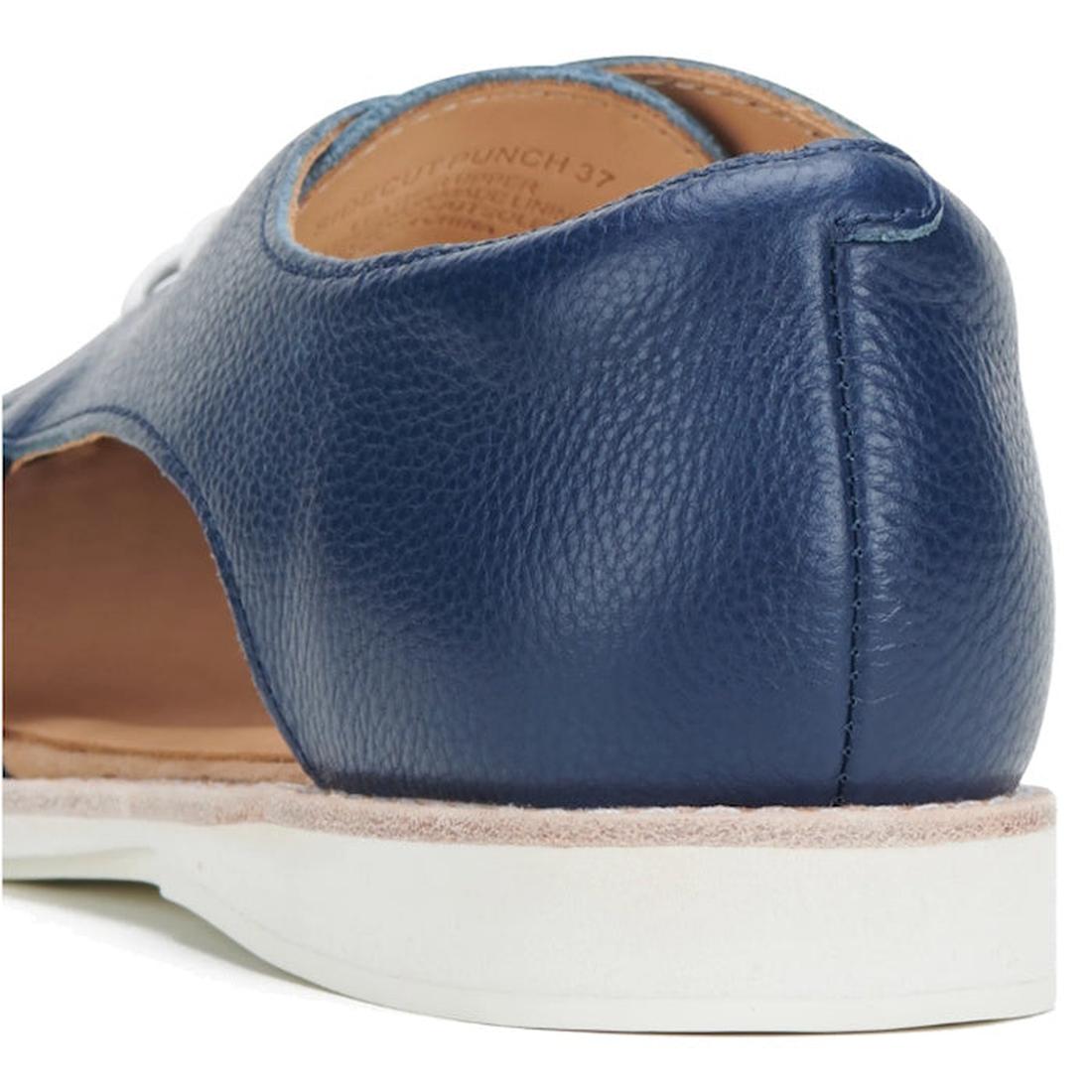 Close-up of the heel and side of the Rollie Womens Sidecut Punch Navy Tumble Leather Shoe, featuring blue leather with white stitching, punch hole detailing, tan breathable lining, and a white anti-slip rubber outsole on a white surface., 9781760775414, 9