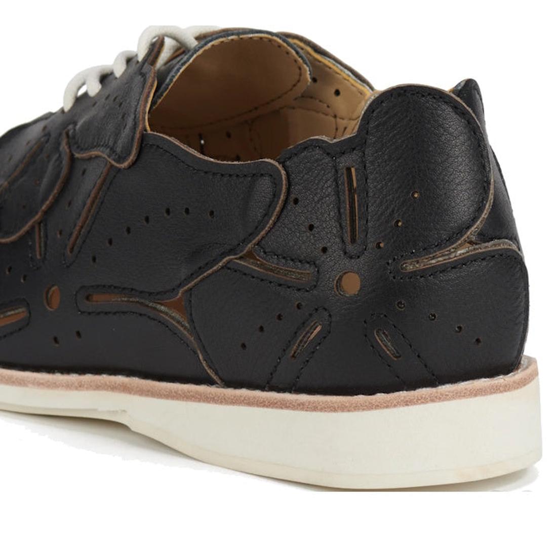 A close-up of the Rollie Derby Applique Black Womens Leather Brogue Shoe shows black leather uppers with floral-shaped perforations, overlays, a white sole, and tan interior lining., 9781760792312, 9781760792329, 9781760792336, 9781760792343, 978176079235