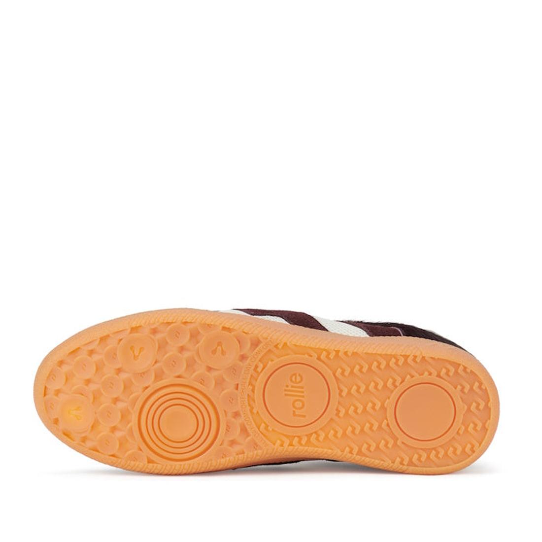 The image shows the orange rubber sole of the Rollie Womens Pace Dark Cherry Bone Suede Sneaker, featuring concentric circles, small raised dots for grip, and "rollie" embossed on its minimalist, textured design., 9339554000315, 9339554000317, 93395540001