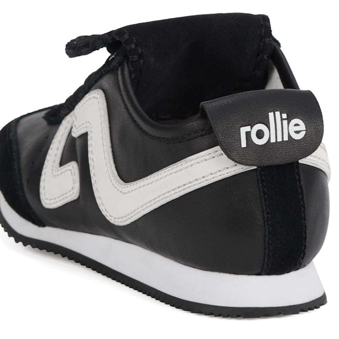 A close-up of the Rollie Womens Shift Black/Bone Sneaker, showing the back and side with a white zigzag design, black heel tab displaying "rollie" in white lettering, and a white sole with a black bottom., 9339554369945, 9339554362427, 9339554100234, 9339
