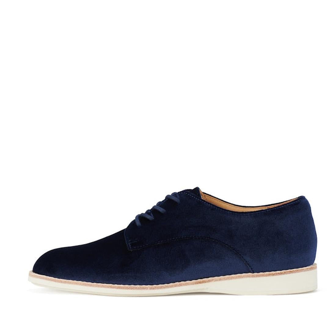 The Rollie Womens Derby Navy Velvet Brouge Shoe features a rounded toe, navy velvet finish, and flat off-white sole, shown in side profile against a white background., 9339554000046, 9339554035741, 9339554028743, 9339554006123, 9339554009810
