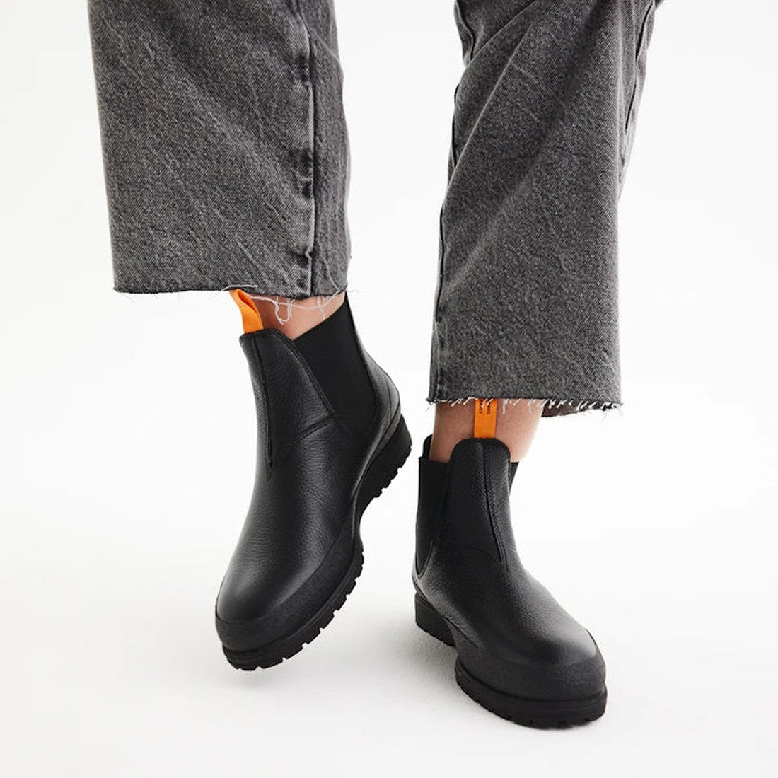 Rollie Womens Fields Chelsea Boots in waterproof black leather, featuring sturdy thick soles and easy slip-on style, shown with grey pants.  ksnz