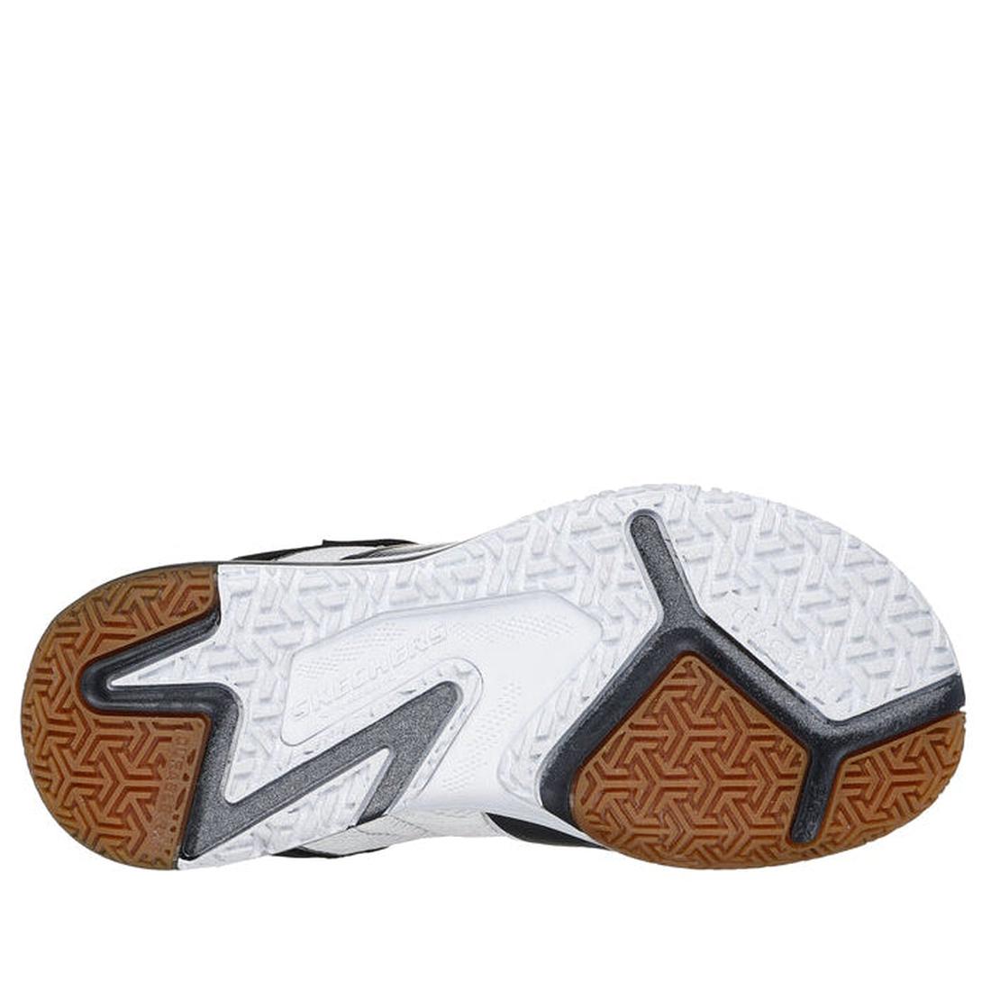 The image shows the sole of the Skechers Boys Elite Sport Court Black/white shoe, featuring white, brown, and black sections with varied tread patterns for grip and traction. The brand name Skechers appears in the center of these athletic sneakers., 19797