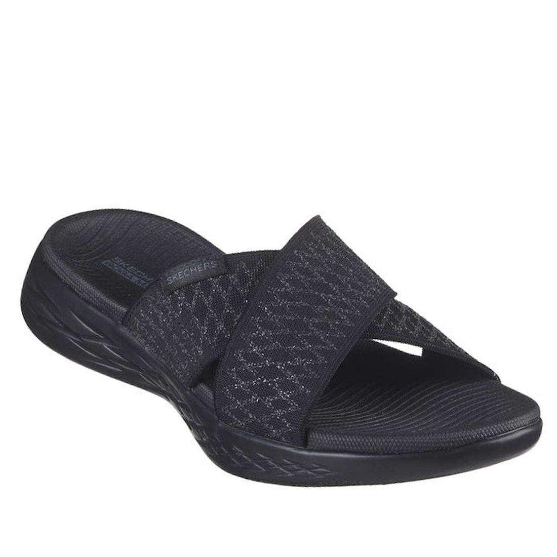The Skechers On The Go 600 Slide Enchanted Black is a women's sandal with two wide, crisscross fabric straps, a textured sole, slightly raised heel, and Goga Mat comfort footbed for all-day wearability.