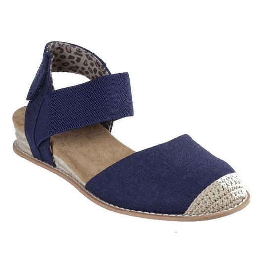 The Skechers Bobs Womens Desert Kiss Sun Shining Low Wedge Sandal in navy features a beige woven toe cap, elastic ankle strap, tan sole, leopard print heel lining, and Memory Foam cushioning—stylish vegan sandals for all-day comfort.