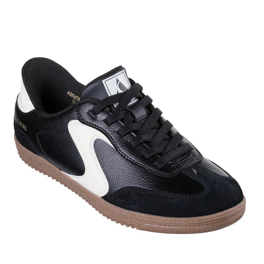 The Skechers Women's HotShot Perfect Choice WIDE Slip-Ins Sneaker in black features white accents, a gum sole, black laces, and a logo on the tongue, shown from a front angle. Designed with Skechers Hands Free Slip-ins for effortless wear and Air-Cooled M