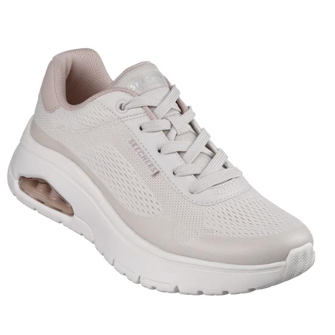The Skechers Womens Uno Flex Spring On Air Taupe Trainer is a light beige sneaker with a thick white sole, visible air-cushioned heel, mesh upper, laces, subtle side and tongue branding, and a comfortable Memory Foam insole.