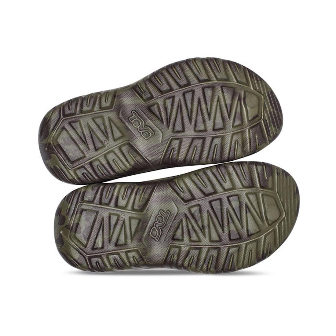 A pair of Teva Kids K Hurricane Drift Huemix Olive Swirl sandals shown from the bottom, featuring textured, grooved rubber soles with the Teva logo embossed on each sole., 196565118264, 196565118271, 196565118356, 196565118295, 196565118301, 196565118318,
