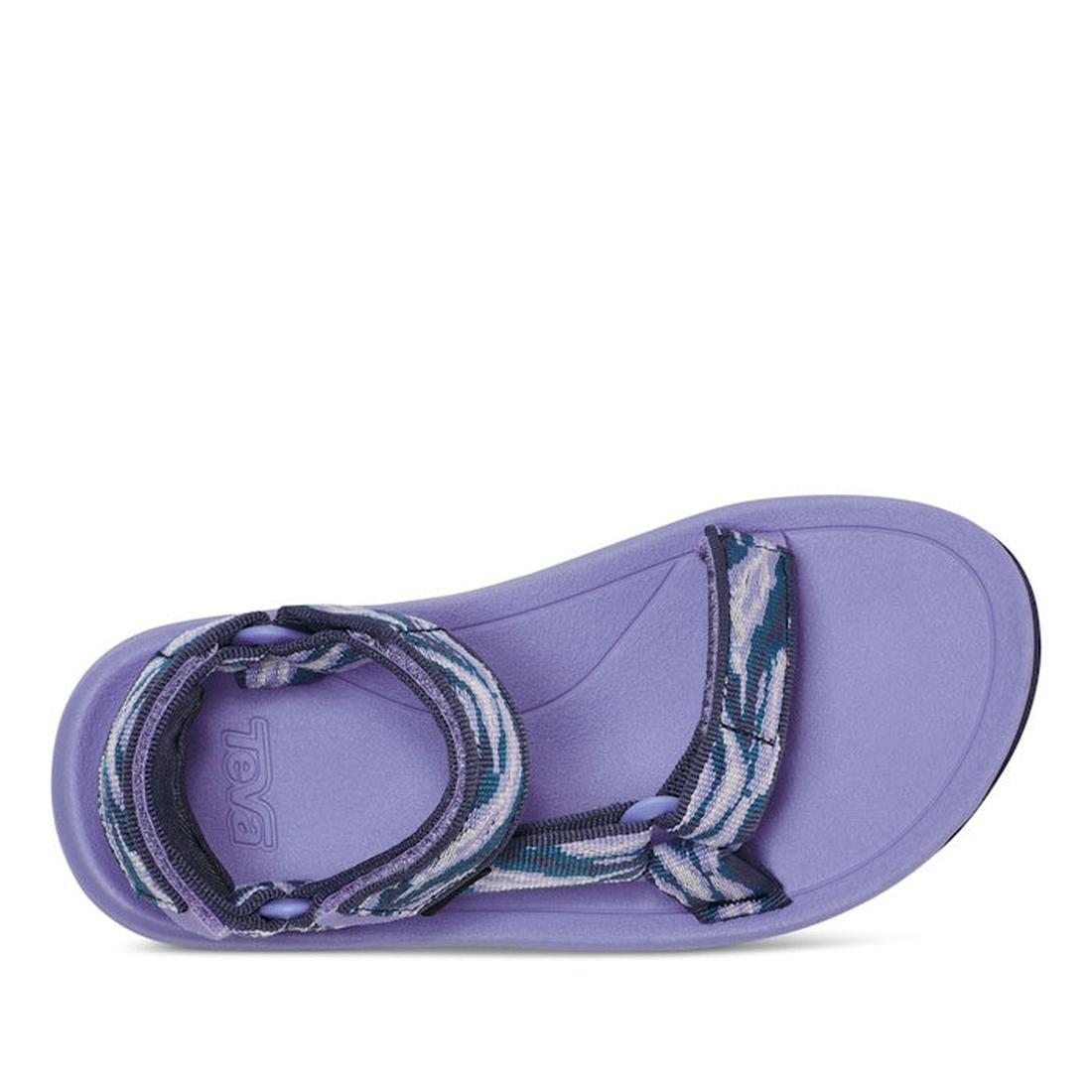 A top view of the Teva Kids K Hurricane XLT2 Waves sandal in pastel lilac purple shows a single sandal with a thick sole, patterned adjustable recycled plastic strap, and the Teva logo embossed near the heel on the footbed., 196565099822, 196565099839, 19