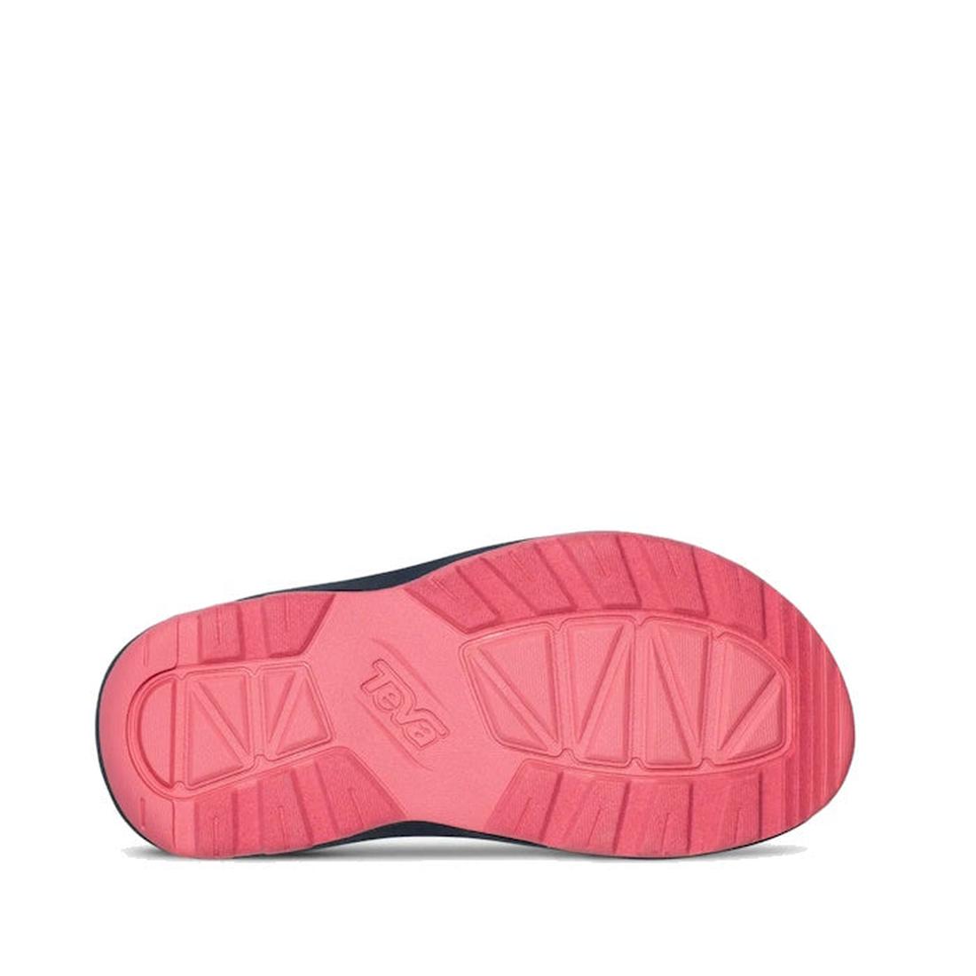 The image shows the underside of the Teva Kids K Hurricane XLT2 Popcorn Multi sandal with a textured pink sole, geometric tread patterns, and the Teva logo embossed in the center. The upper edge is dark blue and made from recycled materials., 196565921888