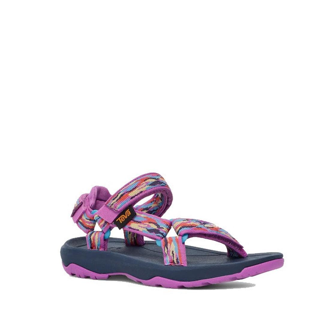 The Teva Kids K Hurricane XLT2 Girls Active Sandal in purple features adjustable rainbow-striped straps, a navy cushioned footbed, and a purple sole—vegan-friendly footwear ideal for vibrant summer style.