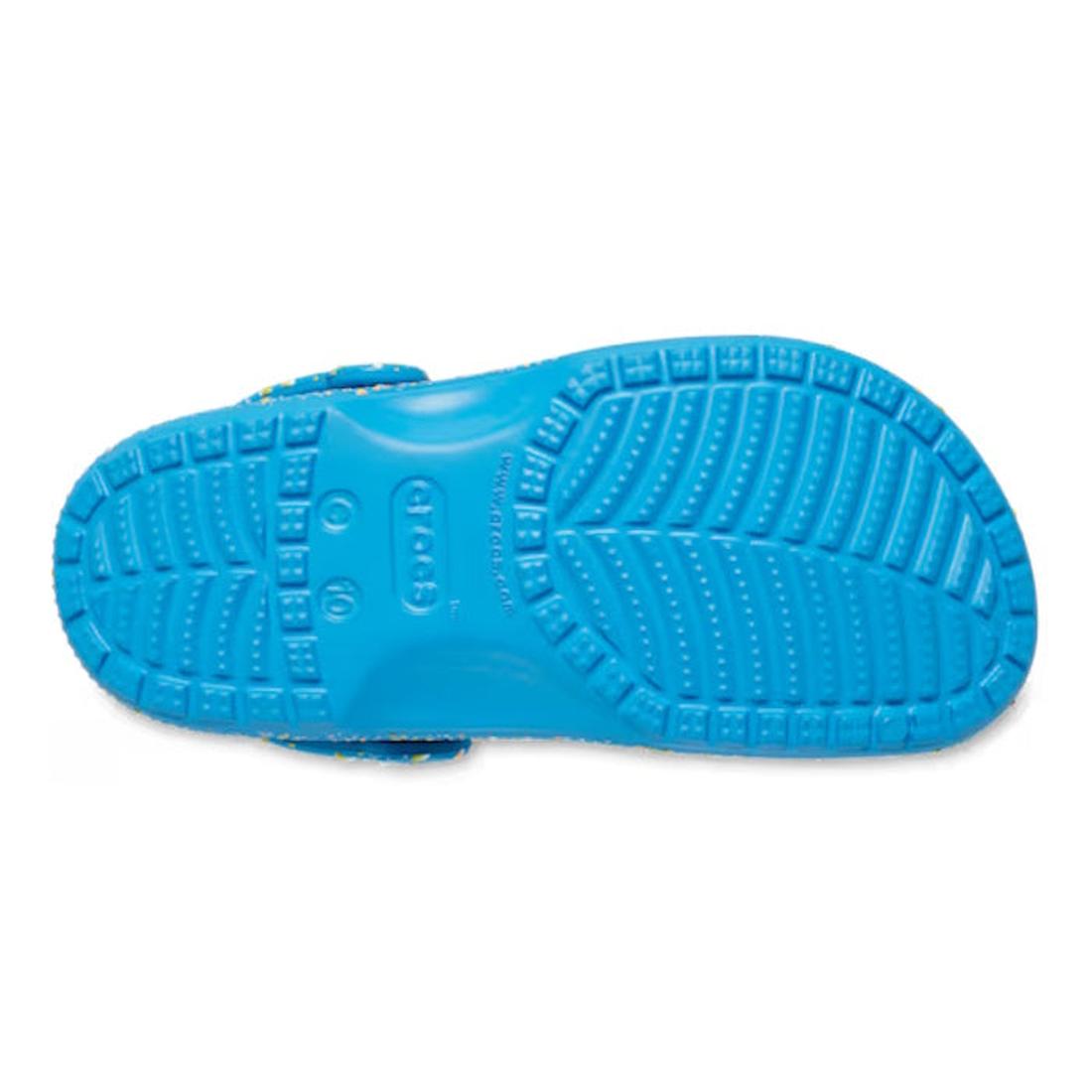 The image shows the bottom view of the Crocs Kids - Toddlers Classic Clog K Paint Splatter Print Blue Pink Multi, highlighting its textured sole for grip and central crocs branding—perfect lightweight shoes for active toddlers., 47582, 198445214134, 19844