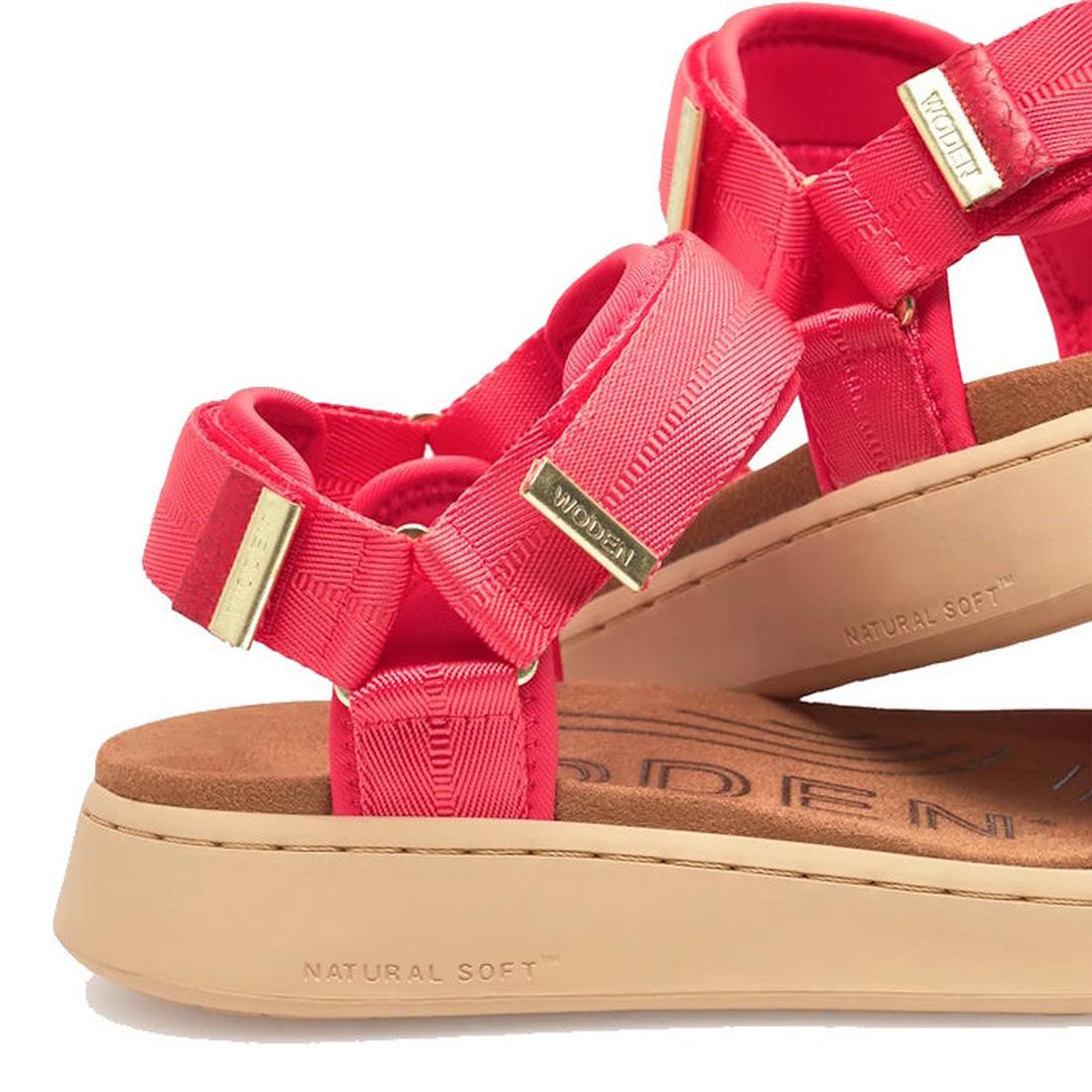 Close-up of the Woden Line Women’s 3 Strap Sandal in Flame Red, featuring gold accents and a tan cushioned sole with “NATURAL SOFT” embossed on the side. Blending Scandinavian design elements, this comfortable sandal offers a sporty and casual style—ideal