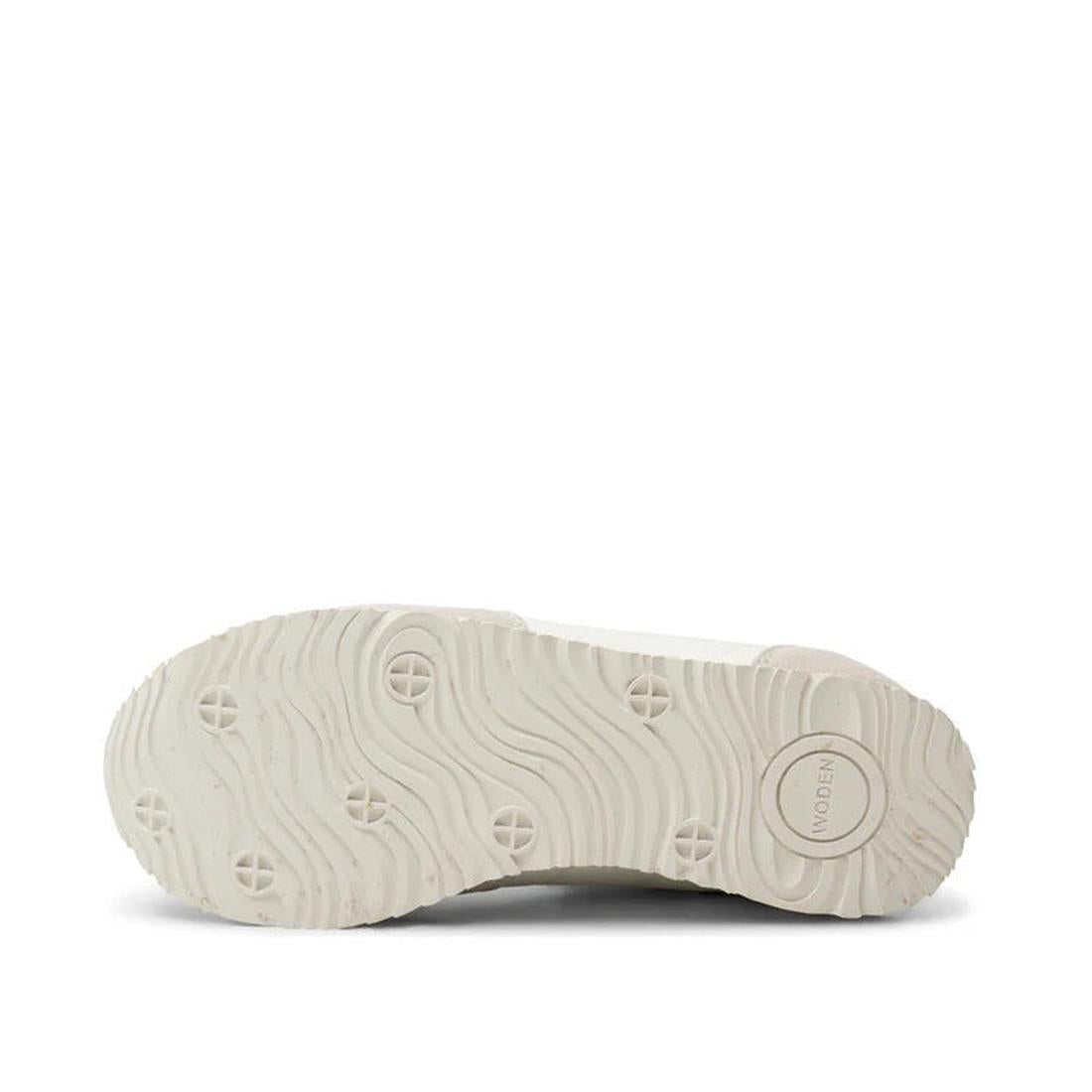 The image displays the white rubber sole of the Woden Womens Sneaker Nora III Nylon/Leather Blanc de Blanc, featuring a wavy tread pattern, circular indents, and 'MODERN' embossed near the heel. The background is plain white., 5713326428360, 5713326428377