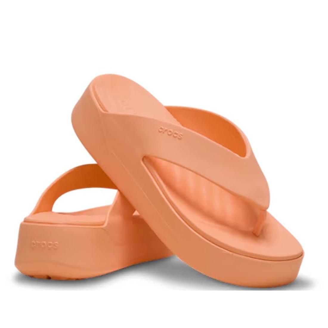 A pair of Crocs - Womens Getaway PLATFORM Flip Sandal in Sunstone Orange, from the Getaway Collection. Foam and Free Feel Technology; thick logo soles—one sandal upright, leaning on the other flat.