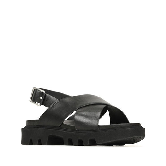 The EOS Womens Flighty Chunky Look Leather Sandal in black features wide crisscross leather straps, a thick rugged sole, and an adjustable ankle strap. The sandal is photographed on a white background.