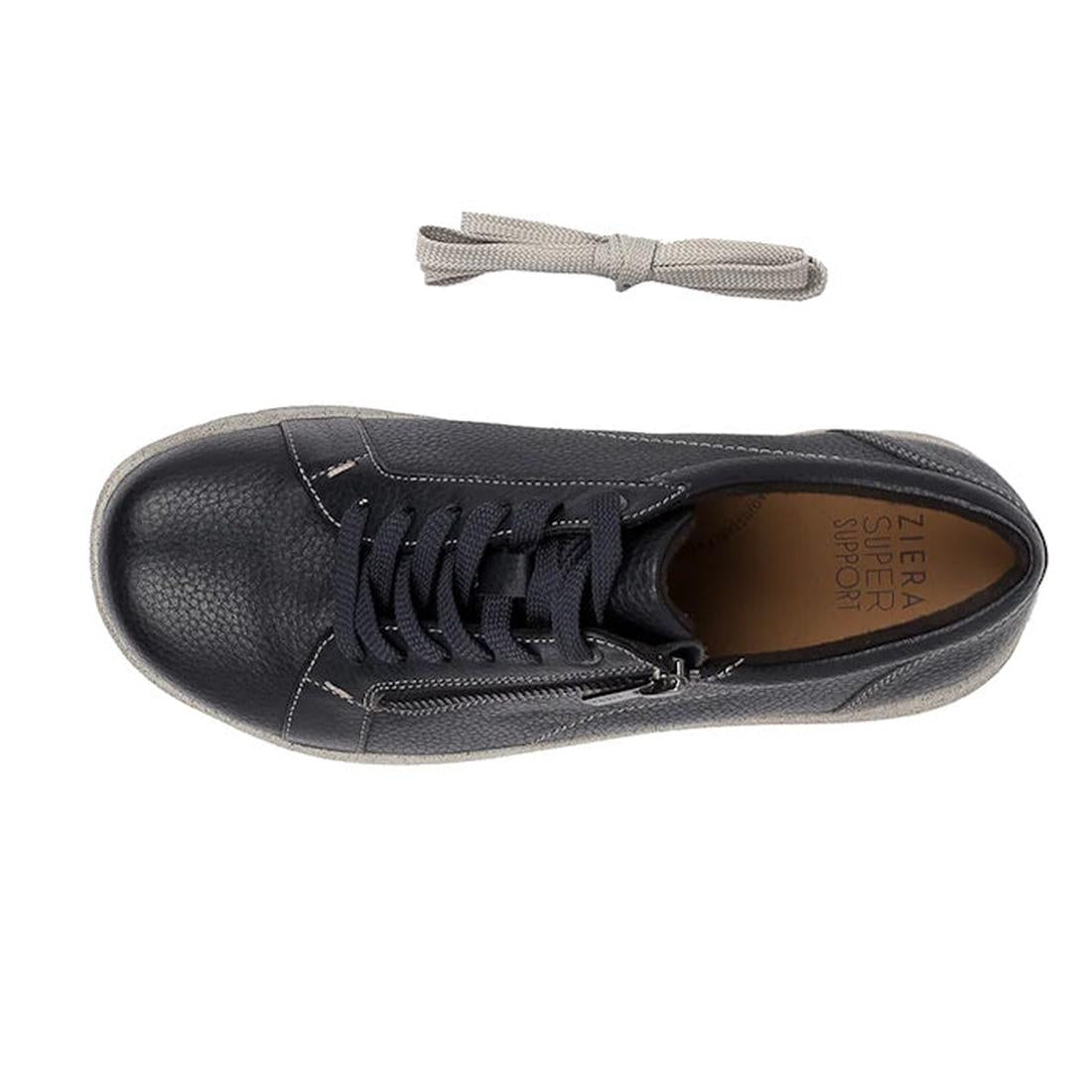 Top view of Ziera Solar XW Women's Casual Sneaker Zip in ink blue leather with a textured toe, black laces, side zipper, and brown insole labeled Ziera Super Support. Designed for extra wide fit and high arch support. Spare light gray laces shown above., 