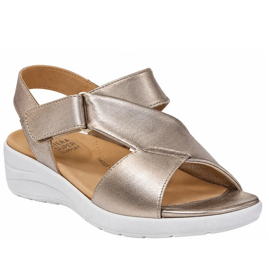 The Ziera Nazly2 Platino Gold White XW Women’s Leather Sandal features a metallic gold open-toe leather design with a thick white sole, an adjustable Velcro ankle strap, and a cushioned tan footbed that provides high arch support, shown against a white ba