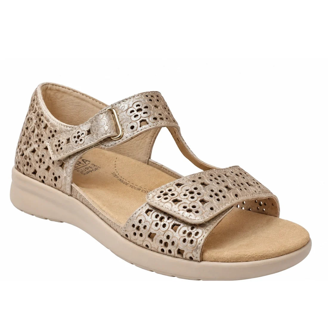 Ziera Bizza Pale Gold XW Women’s Leather Sandal features an open-toe design in pale gold leather with perforated floral patterns, an adjustable Velcro front strap, and a buckle-fastened ankle strap. With an extra wide fit, low beige sole, and cushioned in