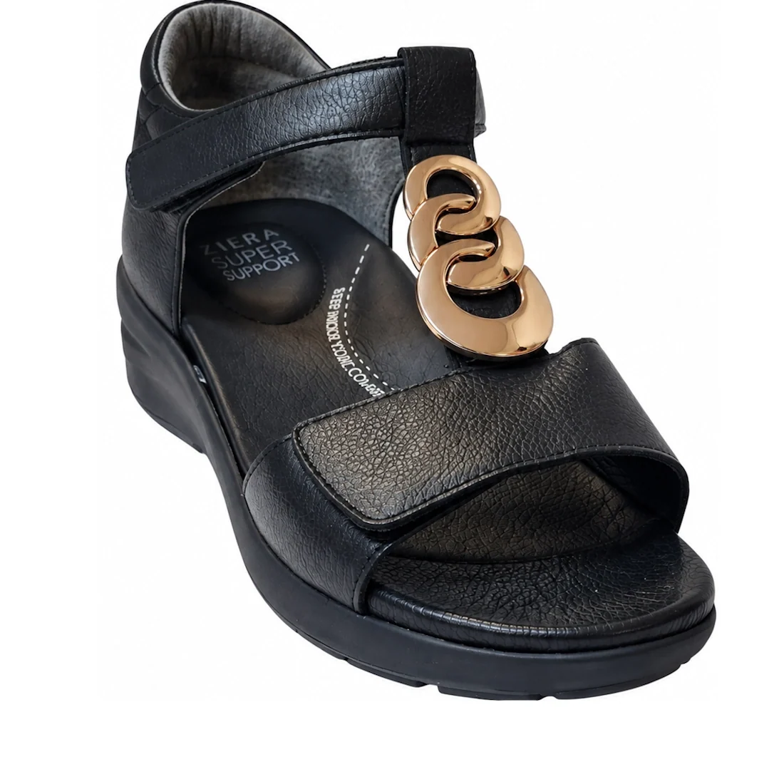 Ziera Nextime Black Leather Womens Sandal with Closed Back XW features a low wedge heel, open toe, and ankle strap. The upper strap is adorned with gold decorative rings, and the insole displays “Ziera Super Support” text. Designed in a wide fit for enhan