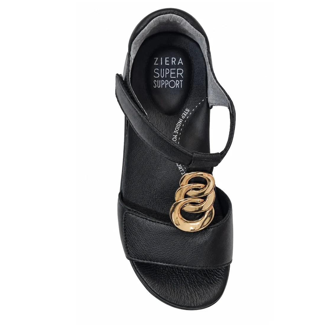The Ziera Nextime Black Leather Womens Sandal with Closed Back XW is shown from a top-down view against a white background. This black sandal features an ankle strap and gold decorative rings on the front, with “Ziera Super Support” printed on the insole 